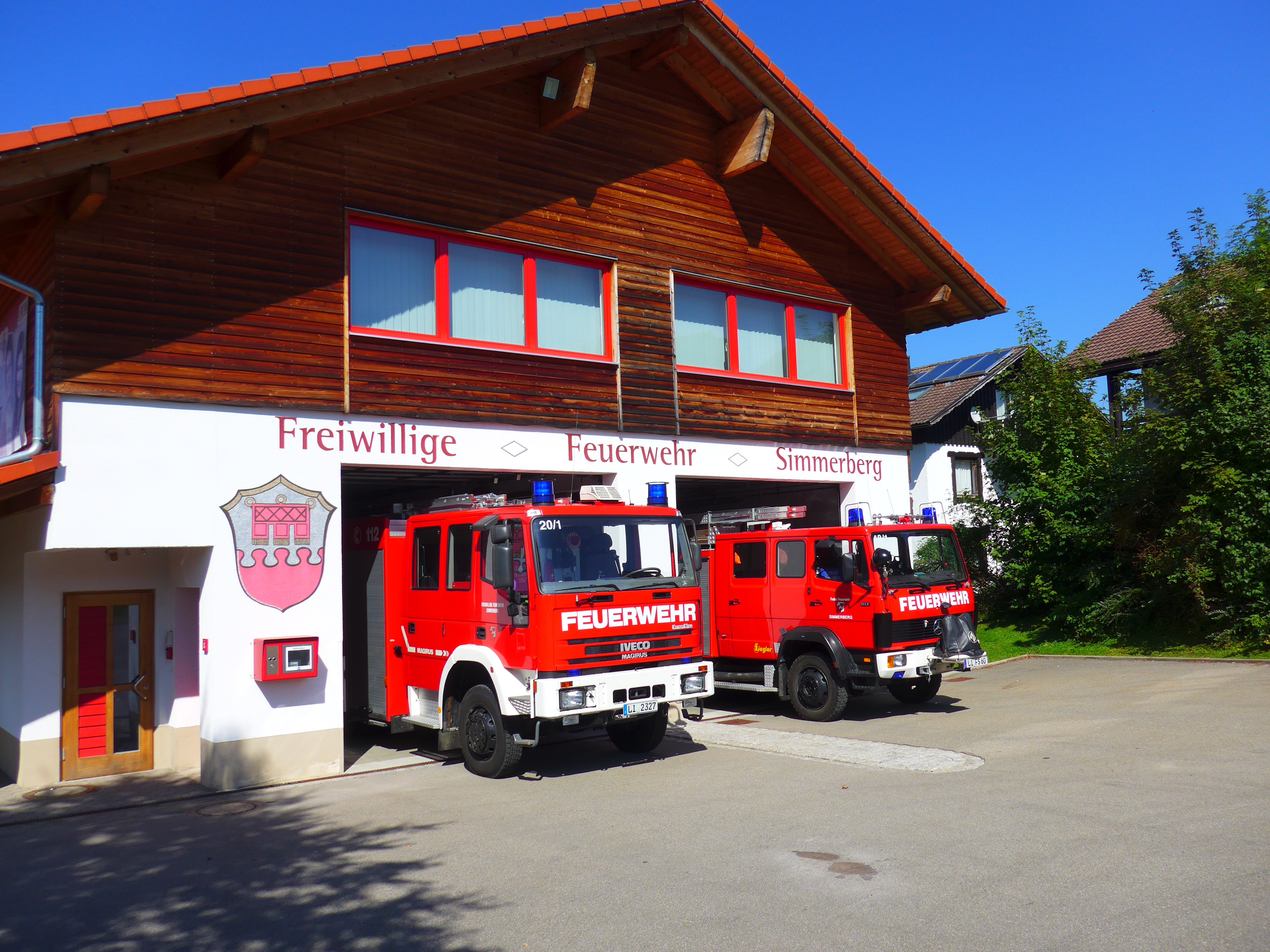  Zwei Einsatzfahrzeuge stehen in der jeweils geöffneten Garage des Feuerwehrhauses Simmerberg - das Bild wird mit Klick vergrößert 
