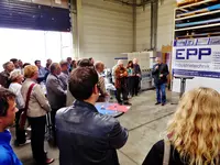 Mehrere Leute hören sich einen Vortrag in einer Halle über Epp Industrietechnik an (Das Bild wird durch klicken vergrößert)